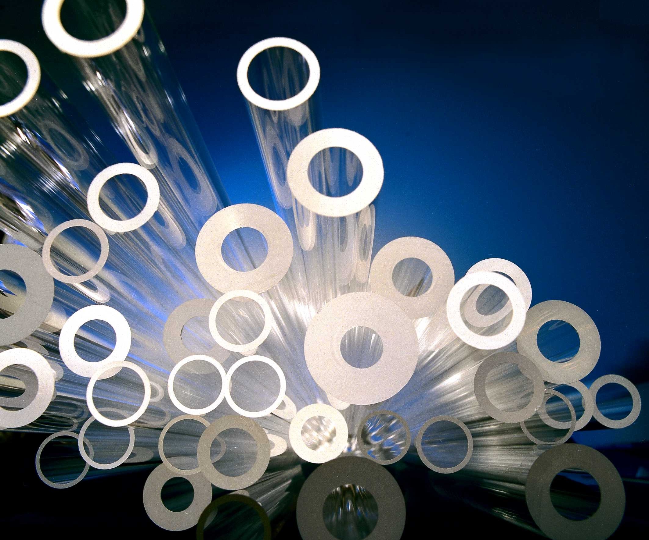 Different versions of glass tubes on a blue background, staged dramatically.