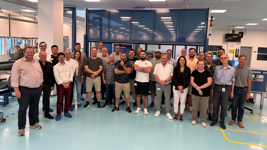 Group photo of the German and Danish colleagues in the interior of the factory