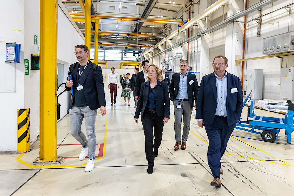 Minister, CEO of Heraeus Comvance and entourage walk through production hall.