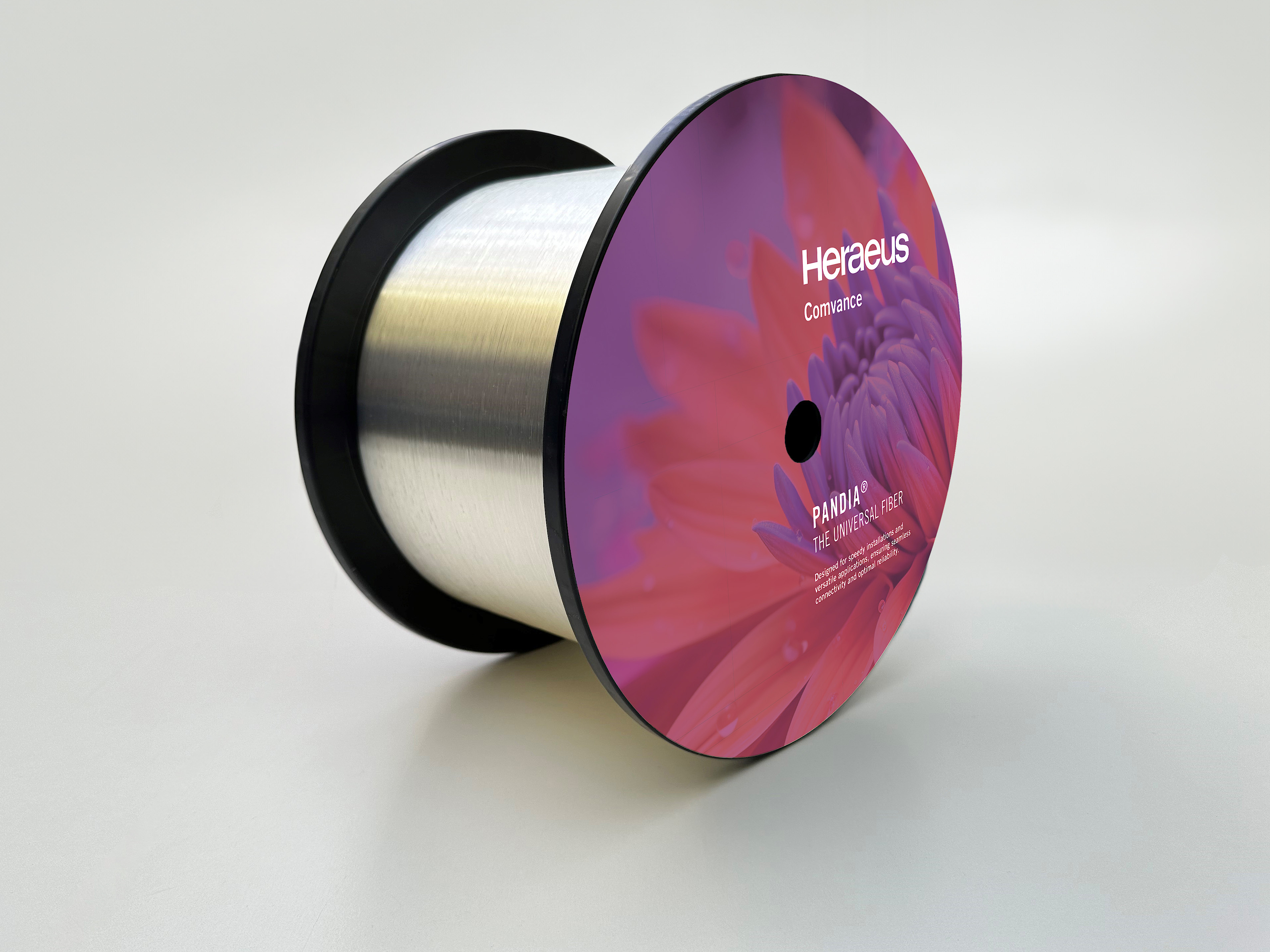 Product image of a fiber optic spool with pink label on a white background